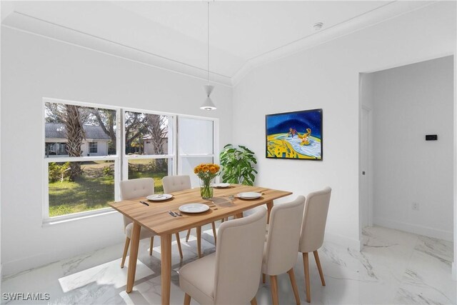 dining space with ornamental molding and lofted ceiling