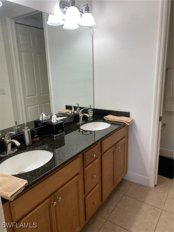 full bathroom featuring tile patterned floors, double vanity, baseboards, and a sink