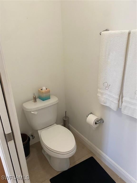 bathroom with tile patterned flooring, toilet, and baseboards