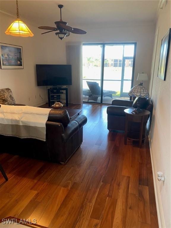 living room with crown molding, wood-type flooring, and ceiling fan