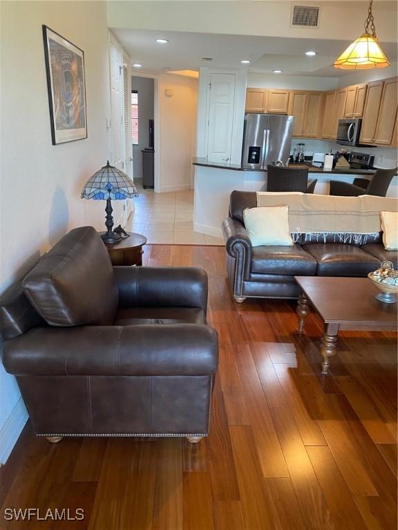 living area with light wood-style flooring, recessed lighting, baseboards, and visible vents