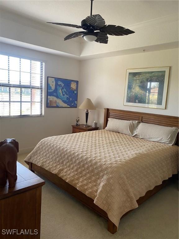 carpeted bedroom with ceiling fan and ornamental molding