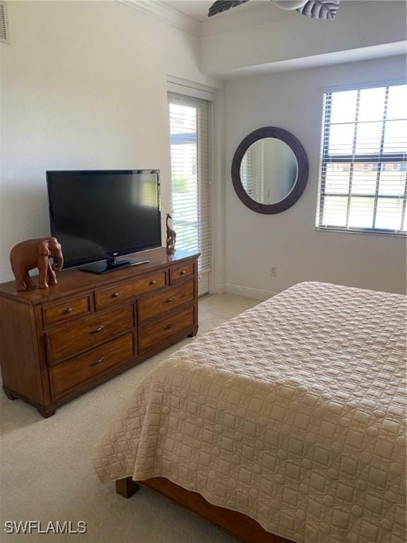 bedroom with visible vents, light colored carpet, and ornamental molding