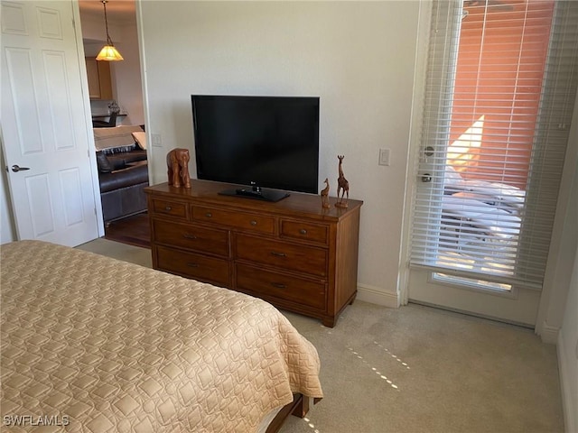 bedroom with light colored carpet and baseboards