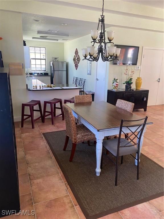 tiled dining space featuring an inviting chandelier