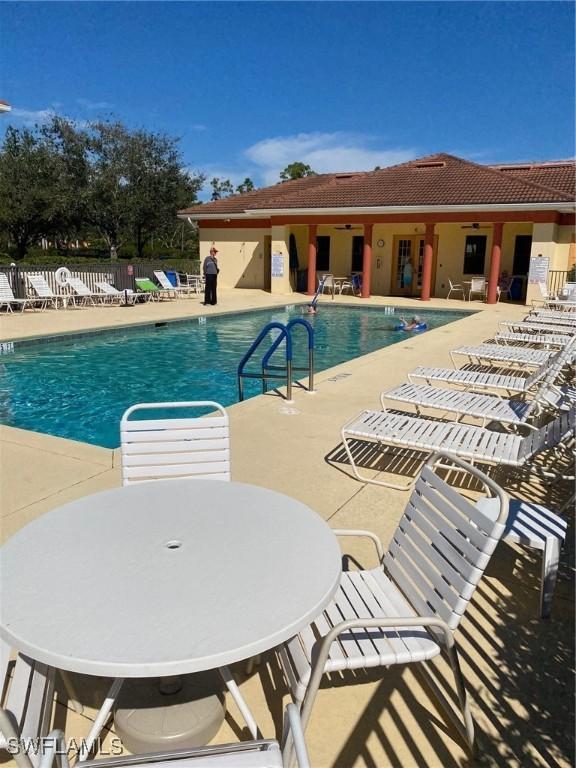 community pool featuring a patio, a ceiling fan, and fence