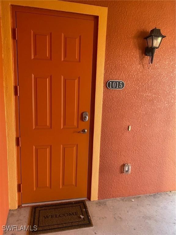 doorway to property featuring stucco siding