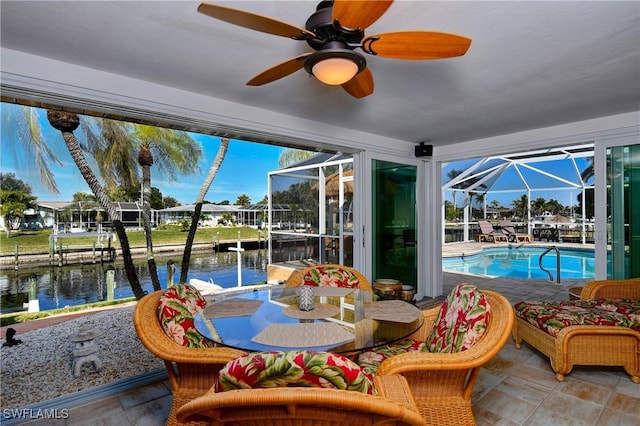 sunroom / solarium featuring a water view and ceiling fan