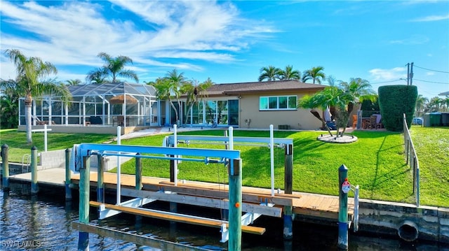 view of dock with a yard, a water view, boat lift, and glass enclosure