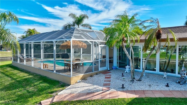 exterior space featuring a patio, glass enclosure, and a lawn