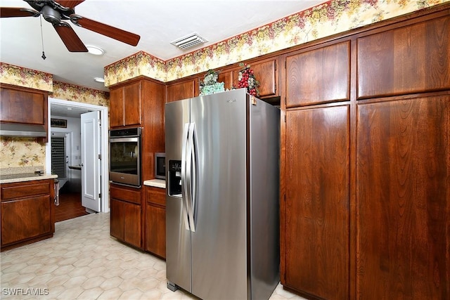 kitchen with light countertops, visible vents, appliances with stainless steel finishes, a ceiling fan, and wallpapered walls