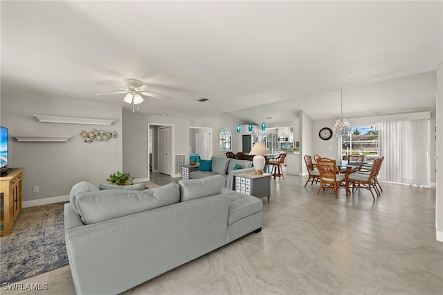 living room featuring ceiling fan with notable chandelier