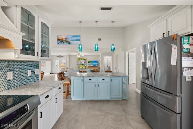 kitchen featuring decorative light fixtures, range, white cabinets, and stainless steel refrigerator with ice dispenser