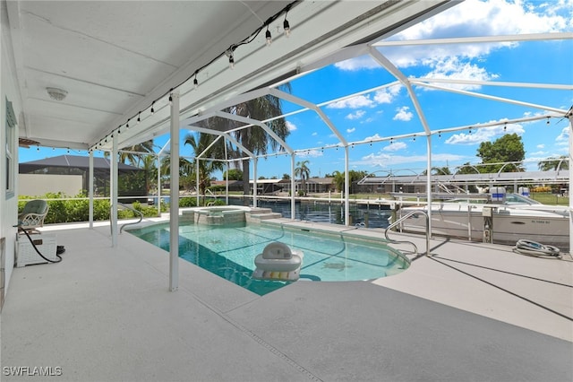 view of pool featuring glass enclosure, a patio area, an in ground hot tub, and a water view