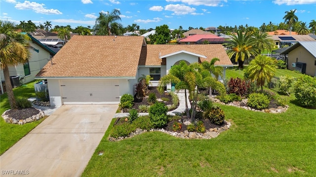 ranch-style home featuring a garage, central air condition unit, and a front yard