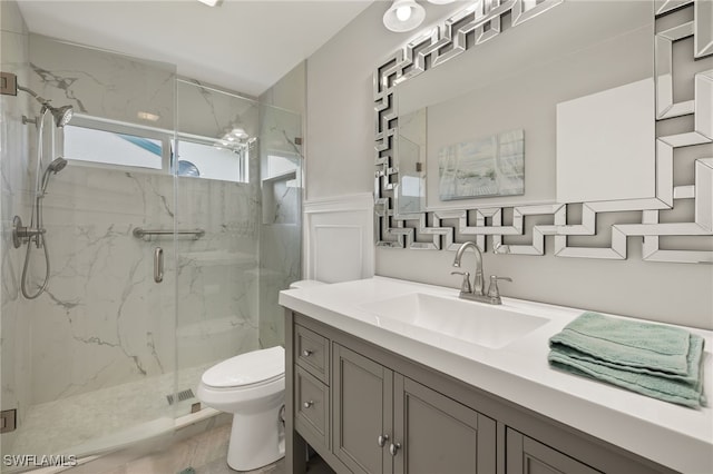 bathroom with vanity, toilet, and a shower with shower door