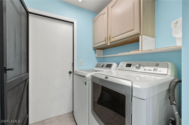 washroom with independent washer and dryer and cabinets