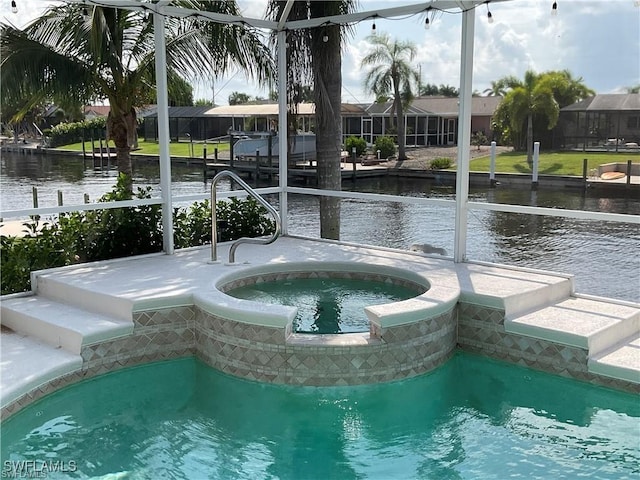 view of pool with an in ground hot tub and a water view