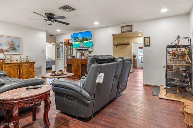 living room featuring dark wood-type flooring and ceiling fan