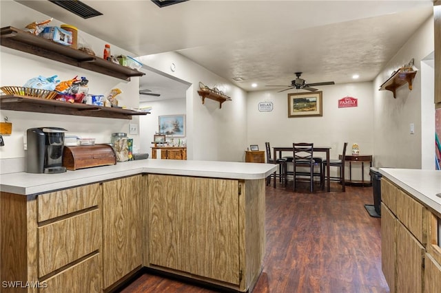 kitchen featuring ceiling fan, dark hardwood / wood-style flooring, and kitchen peninsula