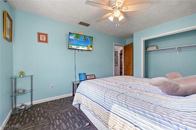 bedroom featuring ceiling fan, dark carpet, and a closet