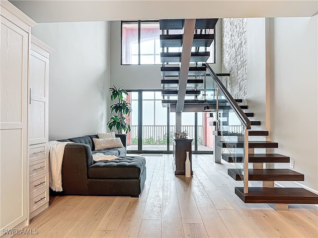 interior space featuring wood-type flooring, plenty of natural light, and a towering ceiling