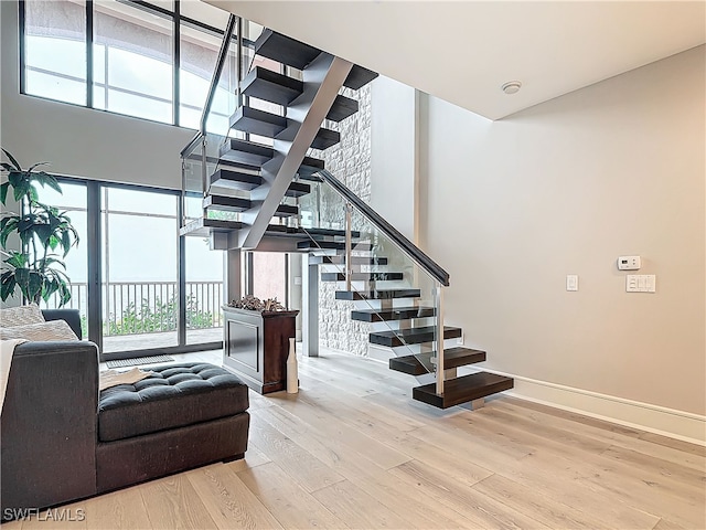 stairs featuring hardwood / wood-style flooring and a high ceiling