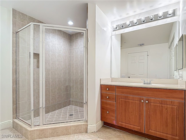 bathroom featuring tile patterned flooring, vanity, and a shower with shower door