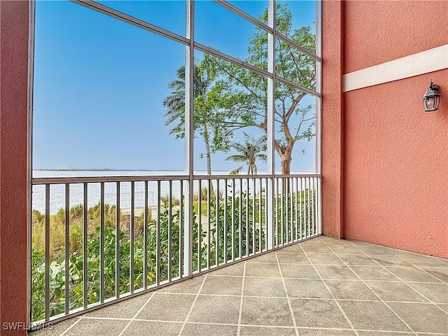 balcony with a water view and a view of the beach