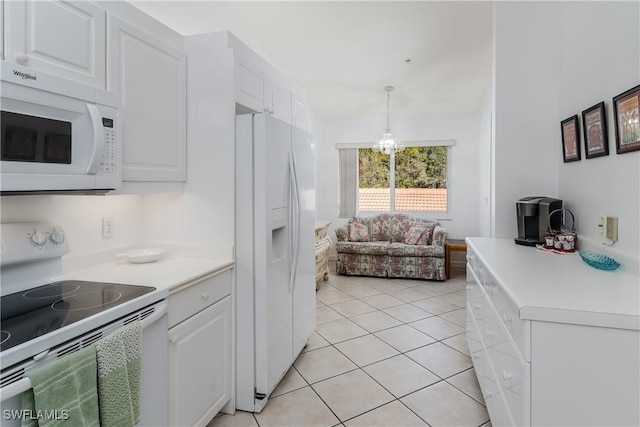 kitchen featuring hanging light fixtures, white cabinetry, light tile patterned floors, and white appliances