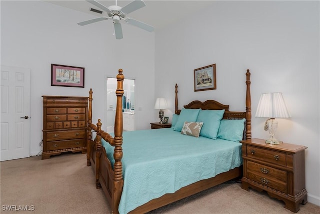 carpeted bedroom with ceiling fan, a towering ceiling, and ensuite bath