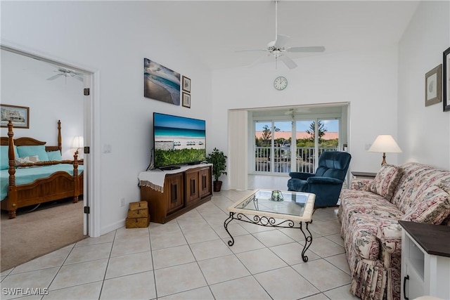 living room featuring ceiling fan, a high ceiling, and light tile patterned floors