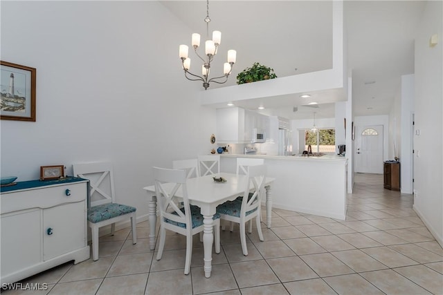 dining room with an inviting chandelier, a high ceiling, and light tile patterned floors