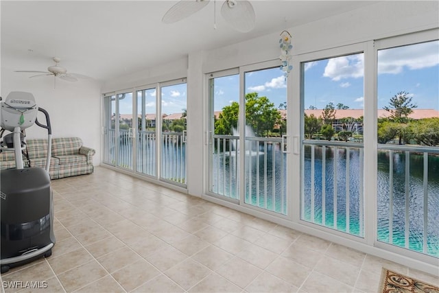 unfurnished sunroom featuring a water view and ceiling fan