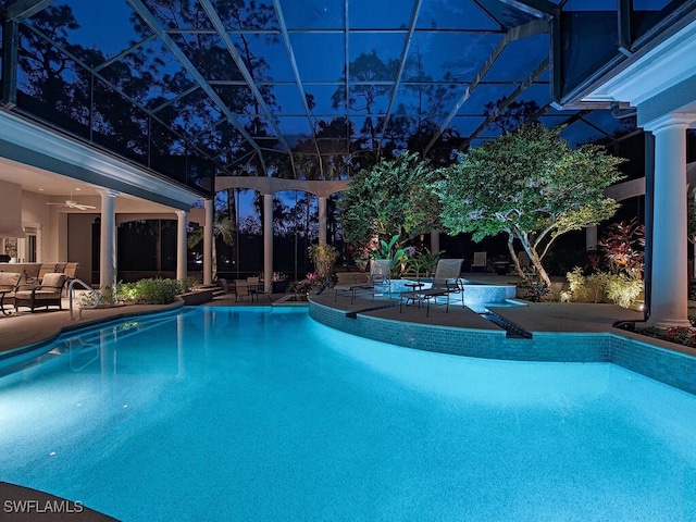 view of swimming pool featuring ceiling fan, a lanai, and a patio area