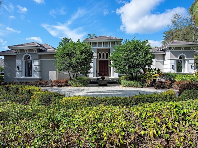 view of front facade with a tiled roof and stucco siding