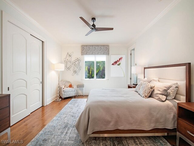 bedroom with baseboards, crown molding, ceiling fan, and wood finished floors