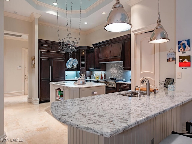 kitchen featuring sink, dark brown cabinets, paneled refrigerator, ornamental molding, and kitchen peninsula