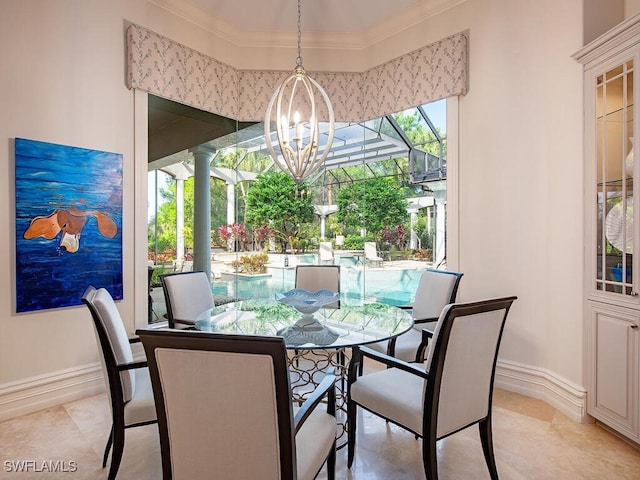 dining room featuring baseboards, a chandelier, crown molding, and ornate columns
