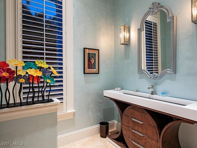 bathroom featuring tile patterned flooring, baseboards, and a sink