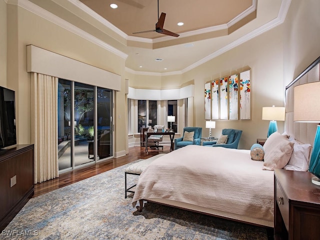 bedroom featuring dark wood-type flooring, ornamental molding, a tray ceiling, and a high ceiling