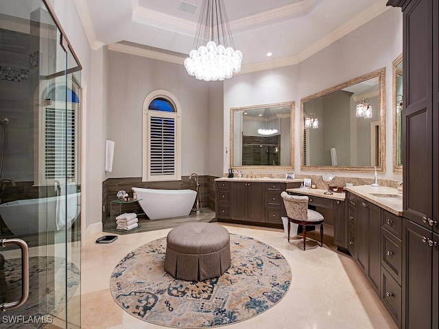 bathroom with a chandelier, vanity, separate shower and tub, a tray ceiling, and crown molding