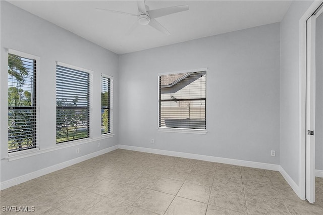 tiled empty room featuring ceiling fan