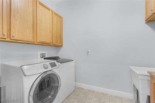 laundry room with independent washer and dryer and cabinets