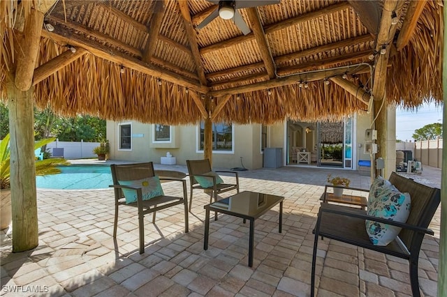 view of patio with a fenced in pool, a gazebo, and ceiling fan