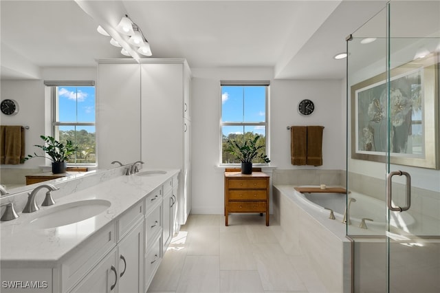 full bathroom featuring a sink, a garden tub, a stall shower, and double vanity