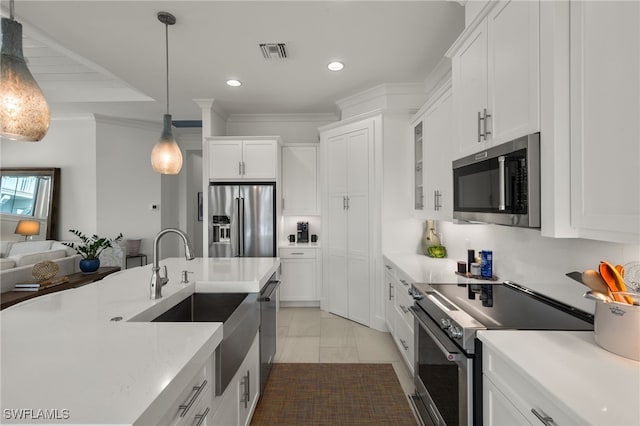 kitchen featuring visible vents, stainless steel appliances, light countertops, and a sink