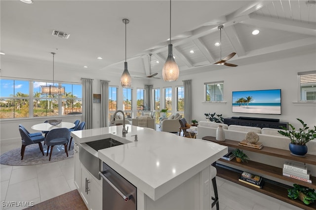 kitchen featuring visible vents, a sink, lofted ceiling with beams, stainless steel dishwasher, and light countertops