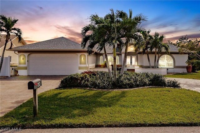 ranch-style house featuring a garage and a yard