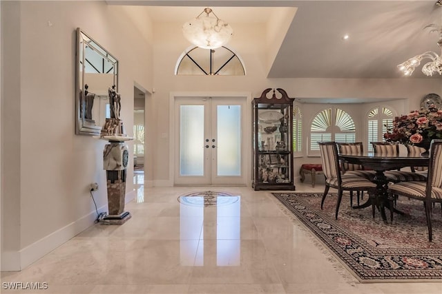 foyer featuring a notable chandelier and french doors